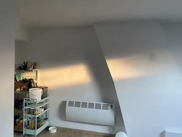 My living room wall highlighted by orange rectangles of light coming from the roof window.