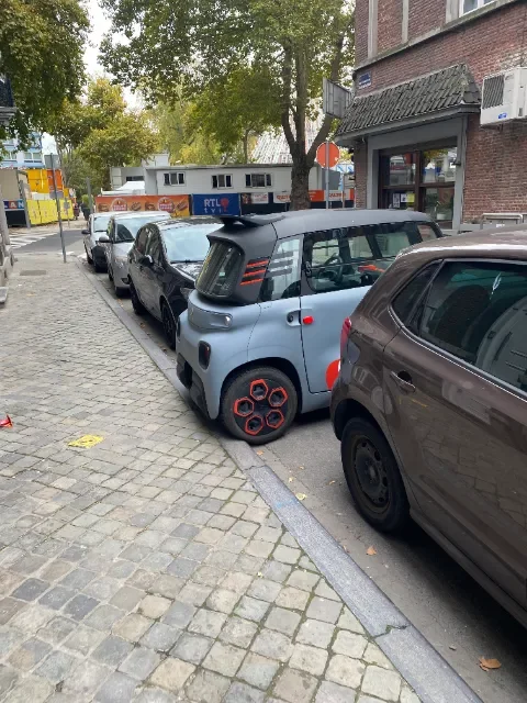 A Citroën Ami parked sideways, cause it's as long as other cars are wide.