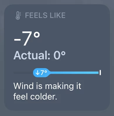A screenshot of the iPhone weather app, showing the "actual temperature" as 0°C and the "feels like" temperature at -7°C.